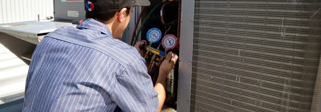 HVAC technician servicing a condenser unit in La Grange Park